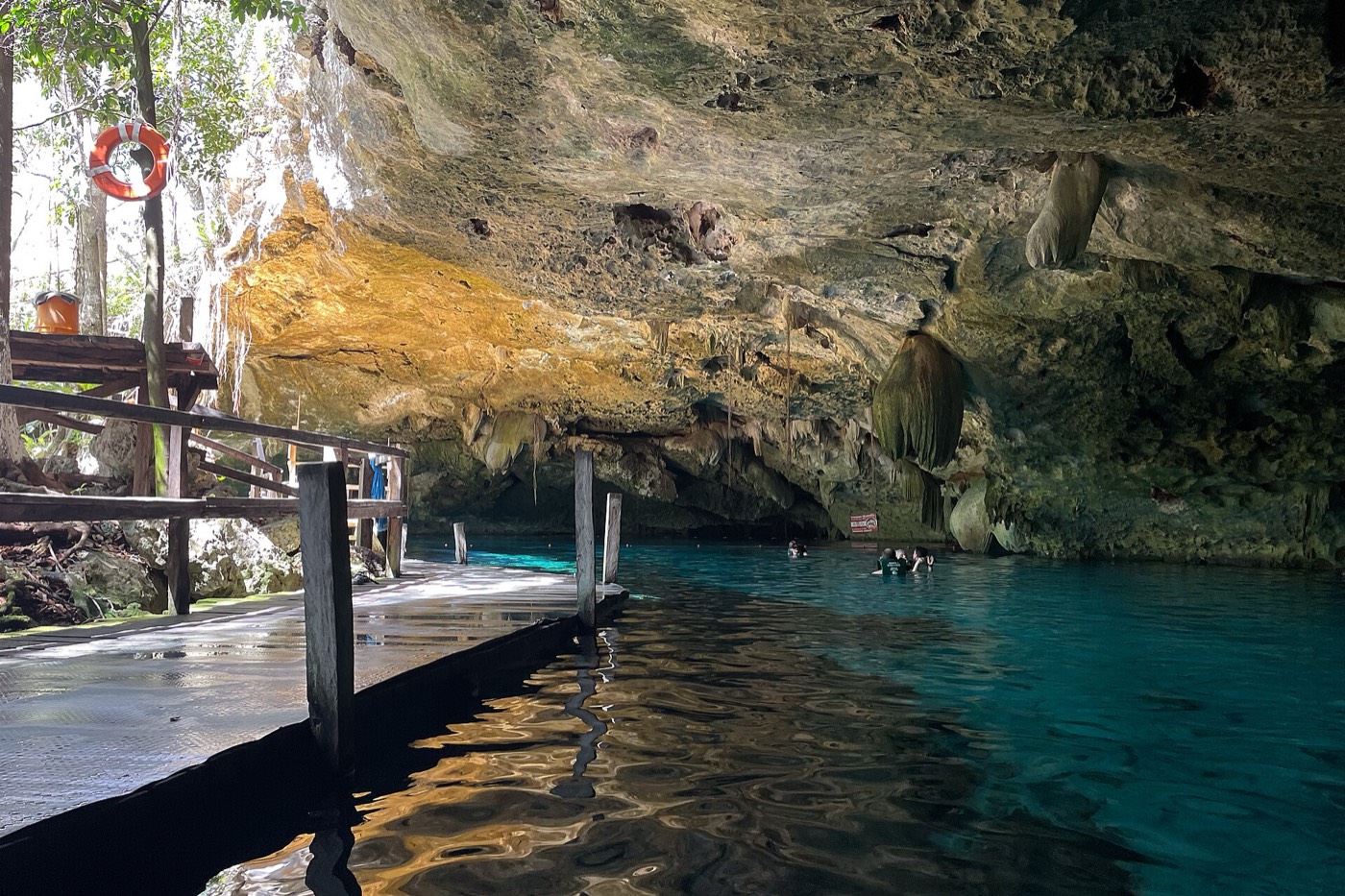 Clear turquoise water under the rock overhang at Cenote Dos Ojos